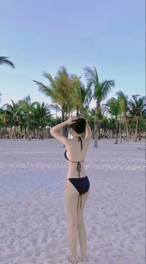 Bộ ảnh đồ bơi che mặt chụp giữa hàng dừa dáng đứng thẳng khoe đùi thon và eo nhỏ