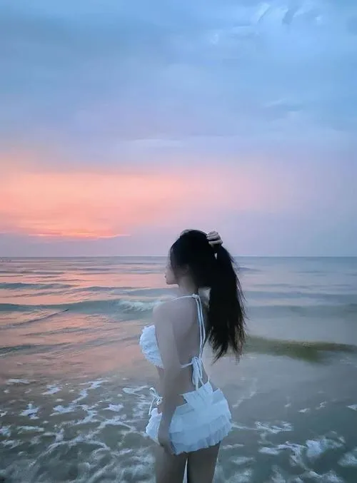 Nàng thơ ngoài biển diện đồ bơi che mặt đứng giữa sóng nhỏ da rám nắng ánh lên gợi cảm kín đáo