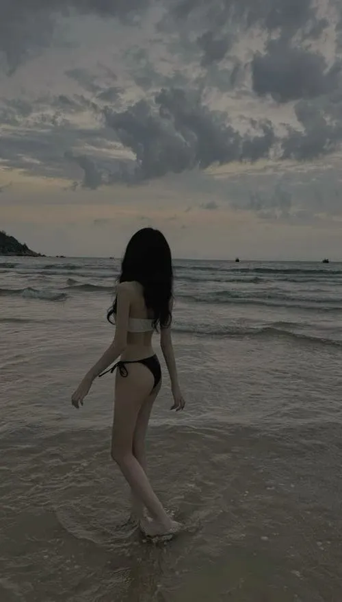 Ảnh gái xinh đi biển mặc bikini che mặt giữa nền trời xám tóc dài che kín ánh nhìn đầy bí ẩn