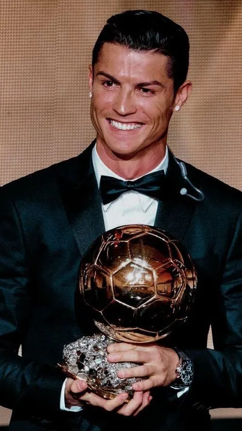 5 Dáng vest đen ôm sát quả bóng vàng, nền sáng làm nổi ánh kim và đường cong cúp.