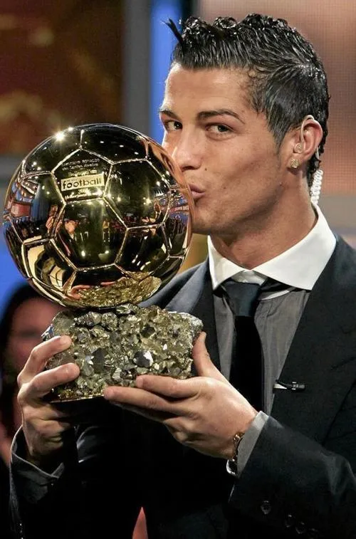 7 Cận cảnh hôn quả bóng vàng, bề mặt kim loại phản sáng, biểu cảm tự hào rất rõ.