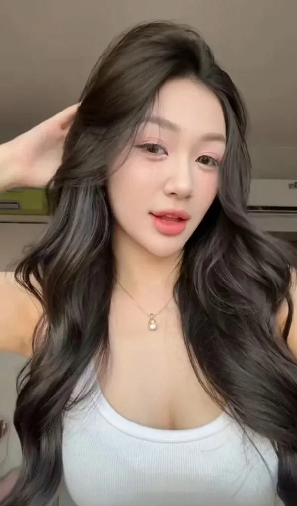 34 Cô bước đi dọc bờ nước, bikini một mảnh, nền biển xanh làm khung hình thoáng.