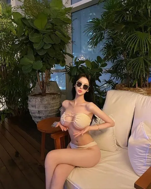 70 Cô gái buộc tóc cao, bikini đỏ, cổ dài, dáng đứng thẳng đầy năng lượng.