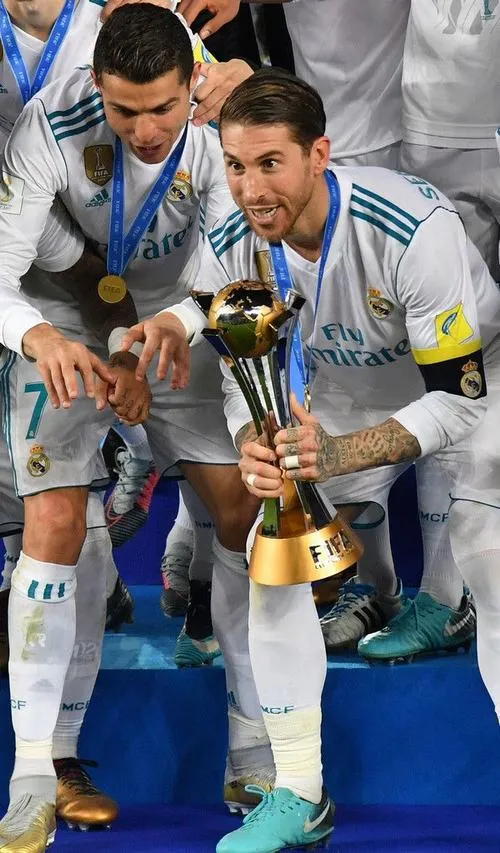 7 Ronaldo cầm cúp đứng giữa đồng đội, bố cục đối xứng, nét mặt nhẹ nhõm sau chung kết