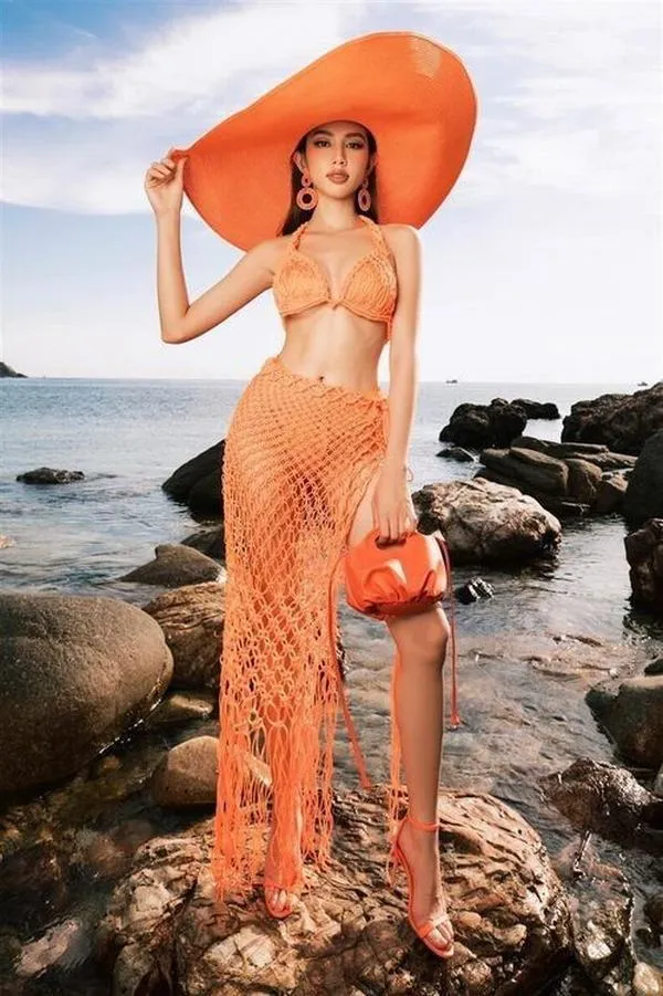 10 Hoa hậu Thùy Tiên đội mũ rộng vành mặc bikini cam, dáng chữ S nổi bật trên bờ đá