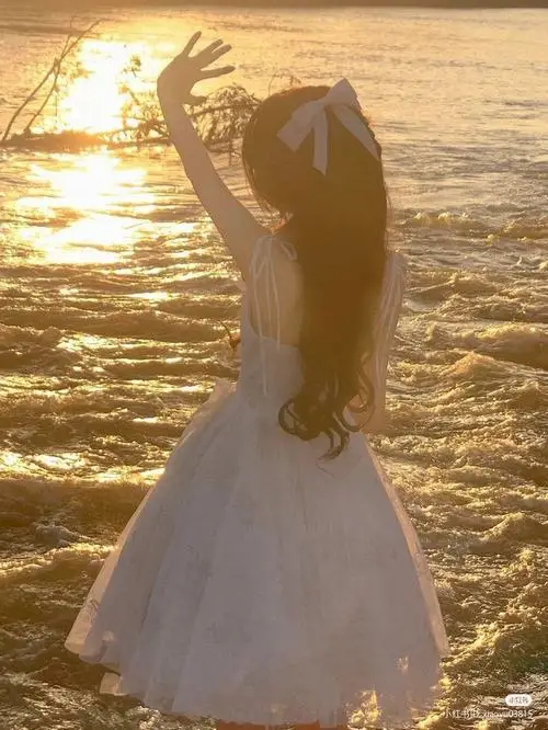 18 Thiếu nữ dễ thương quay lưng trước mặt biển lúc hoàng hôn làm mái tóc dài và váy trắng thêm nổi bật