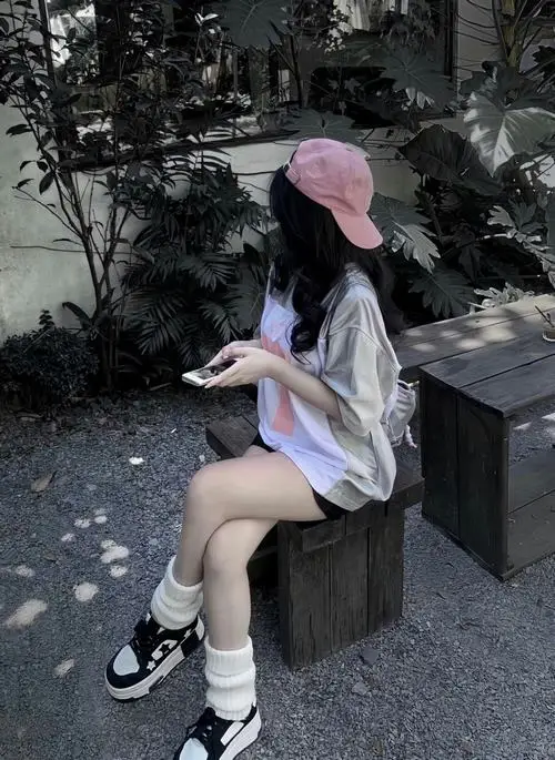 1 Góc ngồi nghiêng của gái xinh đội mũ hồng che nửa mặt làm khung hình mềm mại và rất có gu