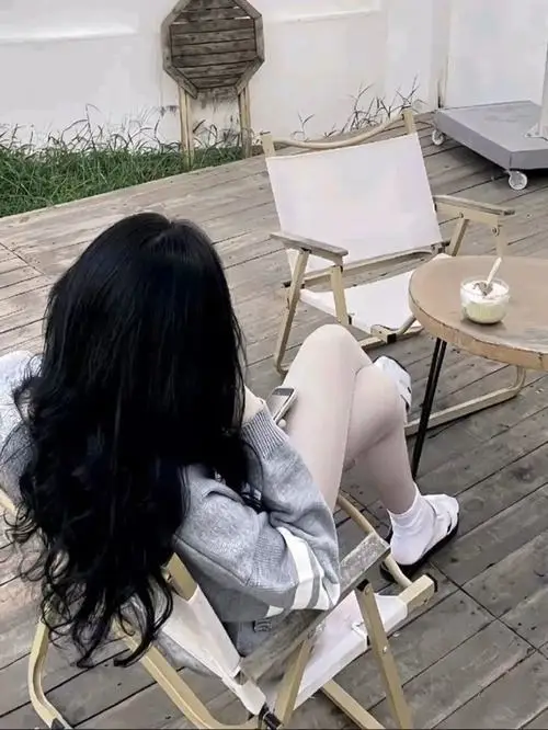 24 Nàng thơ cute ngồi ghế ngoài hiên quay mặt sang bên để tóc che má giúp khung hình thêm mềm mại