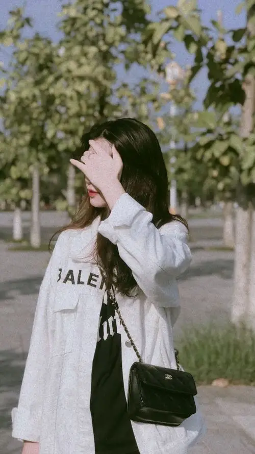 26 Cô gái mặc sơ mi trắng giơ tay che nắng che nửa mặt dưới tán cây tạo cảm giác nhẹ nhàng trong trẻo