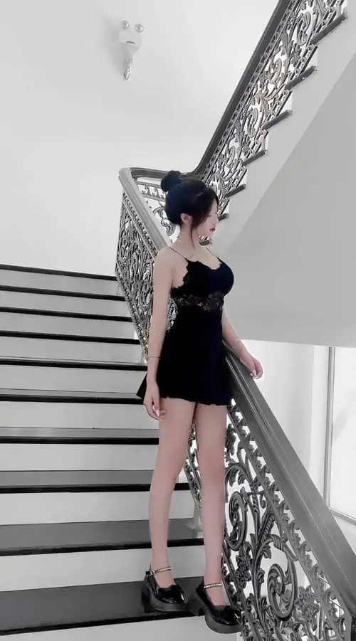 43 Khoảnh khắc nàng thơ mặc váy đen ngắn trên cầu thang trắng, dáng đứng thẳng và mái tóc buộc cao tạo vẻ lạnh lùng, ảnh cô gái mặc đầm này ngầu rõ rệt nhưng vẫn giữ được nét đẹp sang