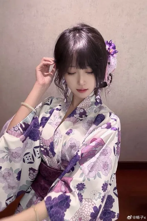 29 Cô gái Nhật diện kimono hoa văn mùa thu obi xanh cầm túi nhỏ cười nhẹ giữa vườn lá vàng