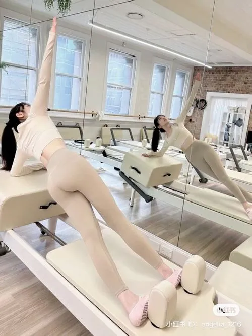 34 Ảnh gái dáng đẹp phòng gym cúi buộc tóc bên thảm tập làm nổi bật vai gọn và đường cong mềm mại