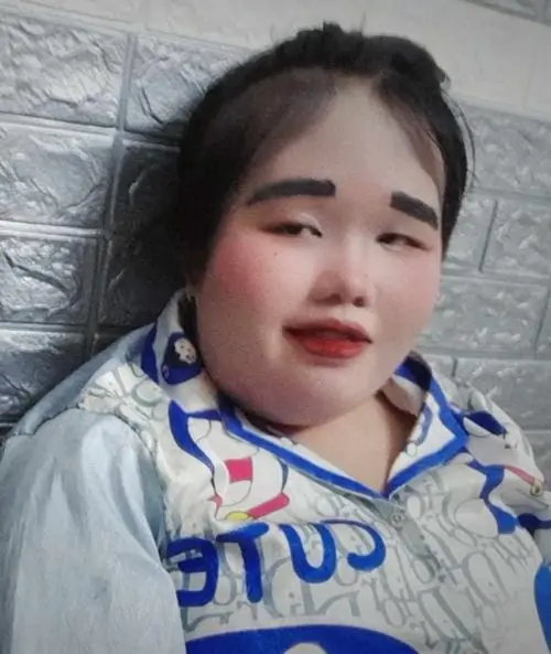 30 Cô bé nằm trên gối với lớp trang điểm đậm, lông mày kẻ cao và môi đỏ nổi bật, tổng thể gợi cảm giác son lem có chủ ý như đang tập hóa trang, nhìn vui mắt hơn là sắc sảo theo lối thông thường