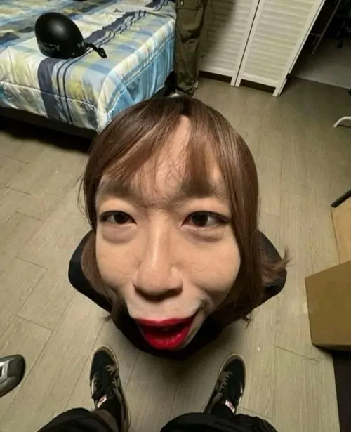 28 Từ góc chụp trên cao trong phòng ngủ, khuôn mặt bị kéo méo thành hình bầu dục dài, mắt mở to và môi chúm lại tạo hiệu ứng dìm góc rất rõ, giống ảnh meme ngẫu hứng mà xem một lần là nhớ ngay