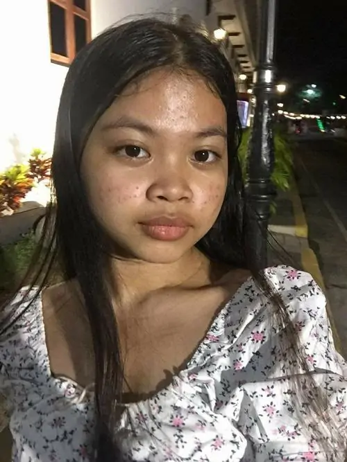 9 Ảnh chân dung nữ chụp ban đêm với áo hoa và ánh đèn phía sau, mái tóc xõa gọn cùng ánh mắt bình thản tạo cảm giác mộc nhan rõ rệt, không quá sắc sảo nhưng lại có sự gần gũi của ảnh đời thường