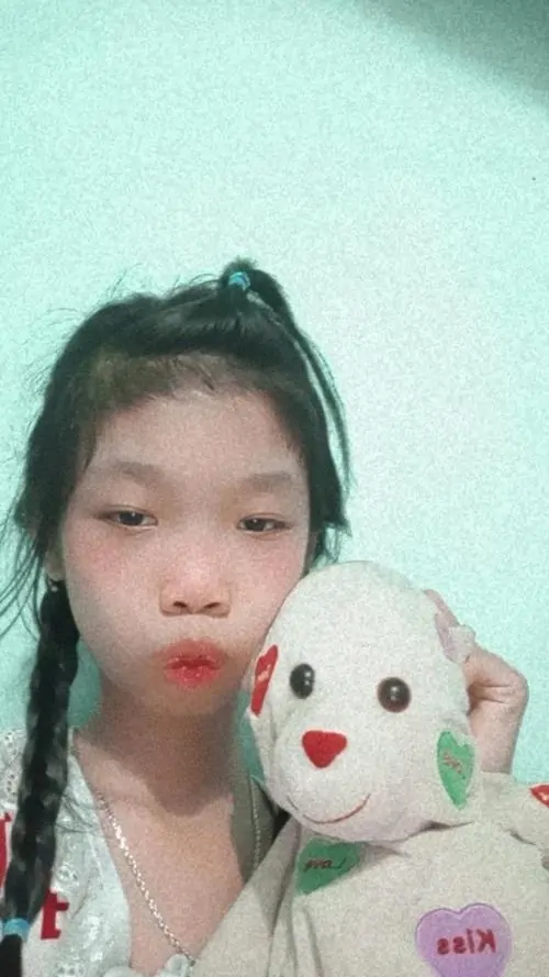 5 Ảnh nhan sắc lạ ghi lại cô bé buộc tóc cao ôm thú bông trắng, đôi môi chúm chím và nền xanh nhạt khiến khung hình vừa ngây ngô vừa lệch chuẩn một cách dễ thương, hợp kiểu ảnh chế hài hước để lưu làm kỷ niệm