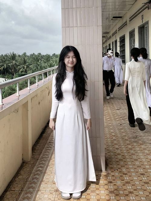 6 Ảnh cô gái buộc tóc thấp mặc sơ mi trắng ngồi đọc sách ở góc bàn gỗ tạo cảm giác dịu dàng và gần gũi