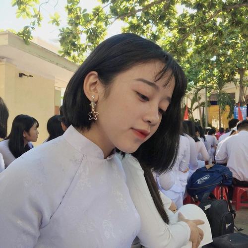 22 Ảnh cô gái cài nơ sau tóc diện váy lụa màu kem bước chậm trên lối đi lát đá nhìn thanh mảnh và dịu