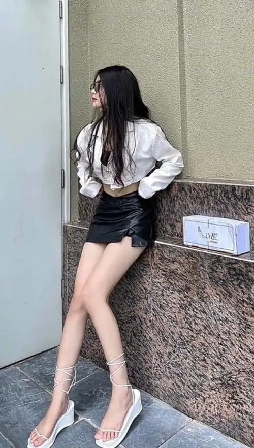 9 Ảnh gái đẹp phong cách Hàn diện sơ mi trắng quần ngắn đen đứng tựa tường đá với visual cực phẩm