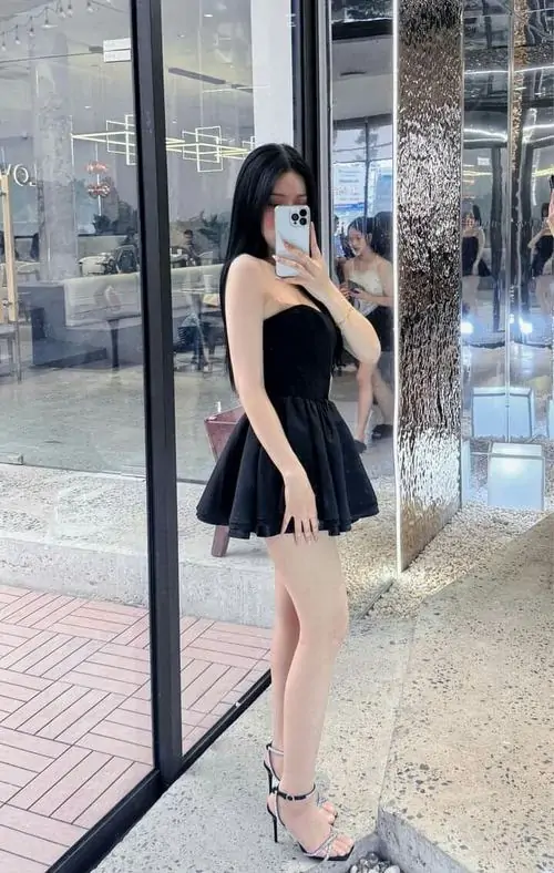 17 Ảnh gái đẹp chân dài trong váy đen đứng trước cửa kính với khẩu trang sáng màu và vẻ sang nhẹ