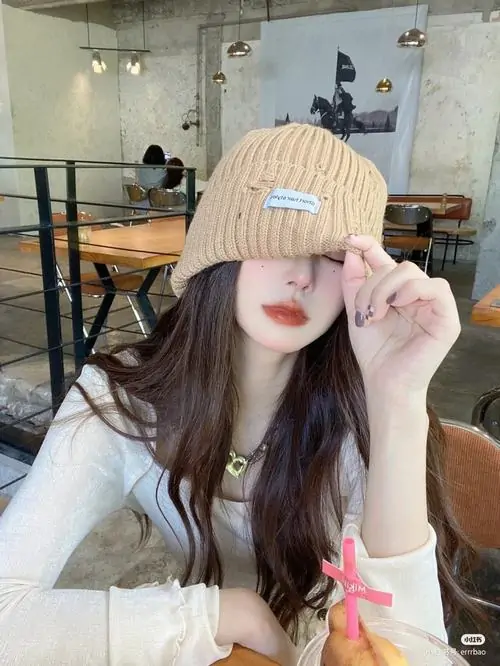 14 Trong quán cà phê sáng màu, cô gái đội mũ len be kéo thấp xuống ngang mắt rồi dùng tay giữ vành mũ, cách che mặt này gọn mà có gu, vừa tạo điểm nhấn phụ kiện vừa làm tổng thể trông mềm và rất xinh