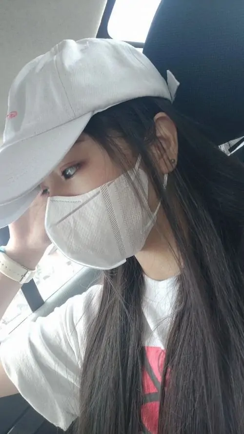 19 Hình thiếu nữ ngầu ngồi trong xe, đội mũ trắng và đeo khẩu trang sáng màu che gần kín mặt, góc chụp cận từ bên hông làm phần tóc đen và quai mũ nổi bật, nhìn đơn giản mà vẫn rất cuốn hút và gọn gu