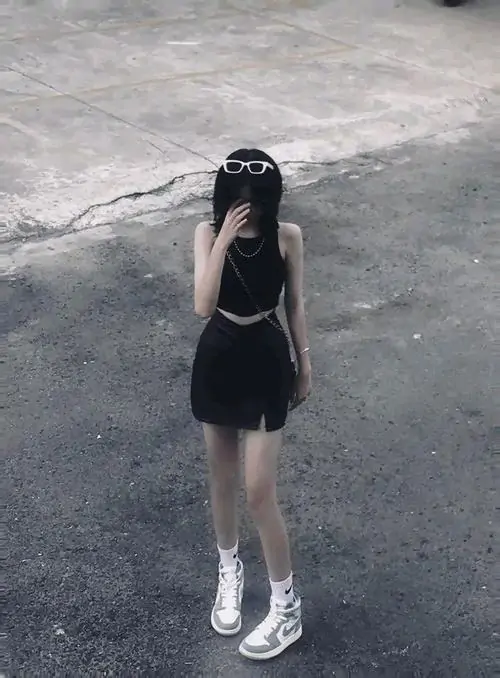 21 Ảnh gái style lạnh chụp toàn thân ở bờ cát tối, cô gái mặc váy đen và đội mũ đen đứng xa ống kính, quay lệch người để gương mặt gần như biến mất trong khoảng tối, bức hình đậm chất bí ẩn và tối giản