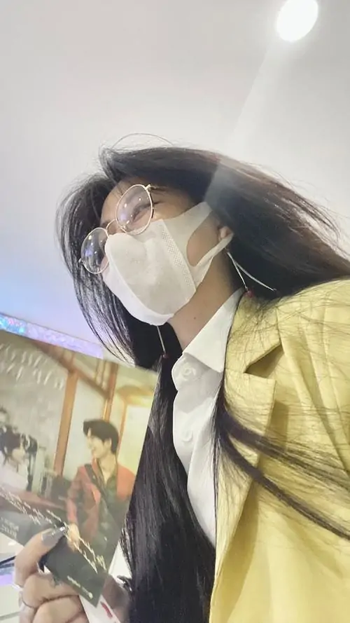 25 Ảnh cô gái chất mặc áo vàng và đeo khẩu trang trắng khi đứng ngoài trời, đầu quay sang bên để đường viền tóc bay và sống mũi hiện nhẹ, kiểu che mặt bằng khẩu trang tạo cảm giác gọn gàng, trẻ và rất hợp xu hướng TikTok
