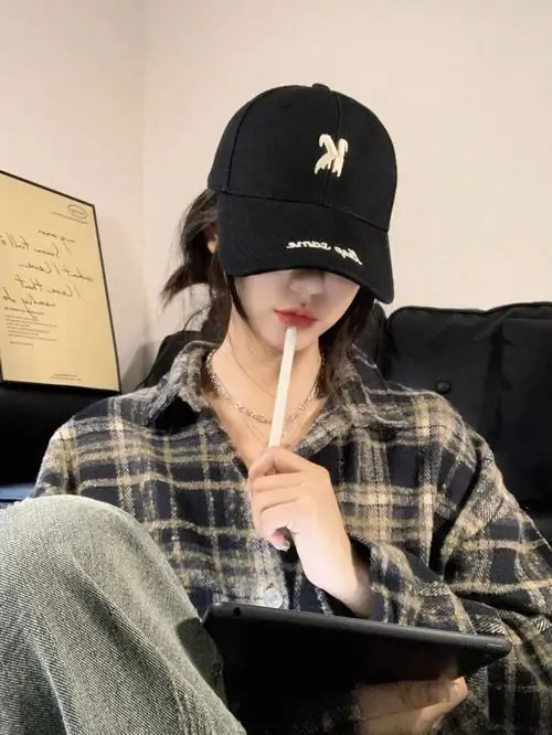 27 Hình gái cool ngầu mặc sơ mi kẻ, đội mũ đen kéo thấp rồi đưa ngón tay chạm môi, phần mặt chìm trong bóng vành mũ nên tổng thể rất cuốn, có nét lạnh khói đúng kiểu che mặt mà vẫn đầy thần thái