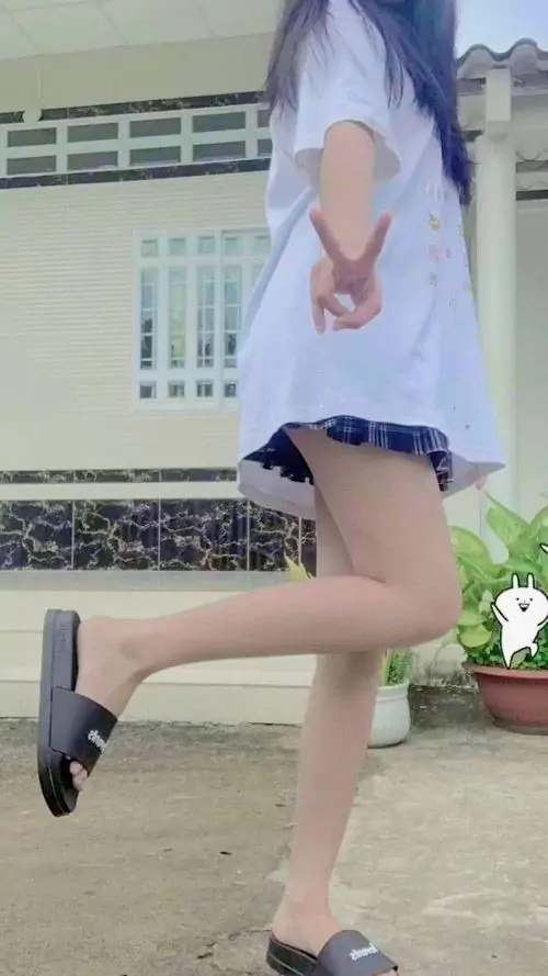 19 Khung hình chỉ lấy phần thân dưới khi cô gái đang bước trên sân, sơ mi xanh dài che bớt hông và đùi, đôi chân cùng giày cao làm hiệu ứng hack dáng hiện rõ, trông lạ mắt và khá cuốn