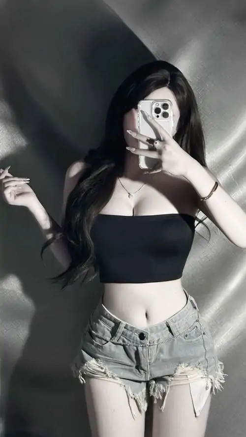 40 Tông đen trắng làm nổi bật cô nàng mặc áo quây tối cùng quần jeans sáng, phần hông lệch nhẹ trước nền tối khiến đường cong hiện rõ, cảm giác ngầu lạnh nhưng vẫn cuốn, hợp kiểu ảnh gái đẹp tạo dáng