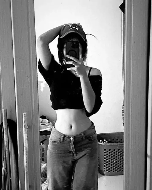 37 Tông đen trắng trong phòng giặt nhỏ khiến cô gái mặc áo tối ôm và jeans cạp cao nổi bật hơn, tay đưa lên đầu tạo đường cong rõ ở eo, khung hình ngầu, cá tính và vẫn giữ vẻ nữ tính