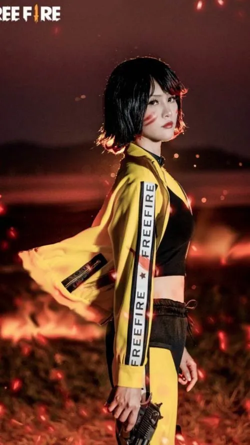 26 Ảnh gái xinh cosplay Free Fire mặc áo vàng dài bay nhẹ giữa nền đỏ tạo cảm giác bụi bặm ngầu