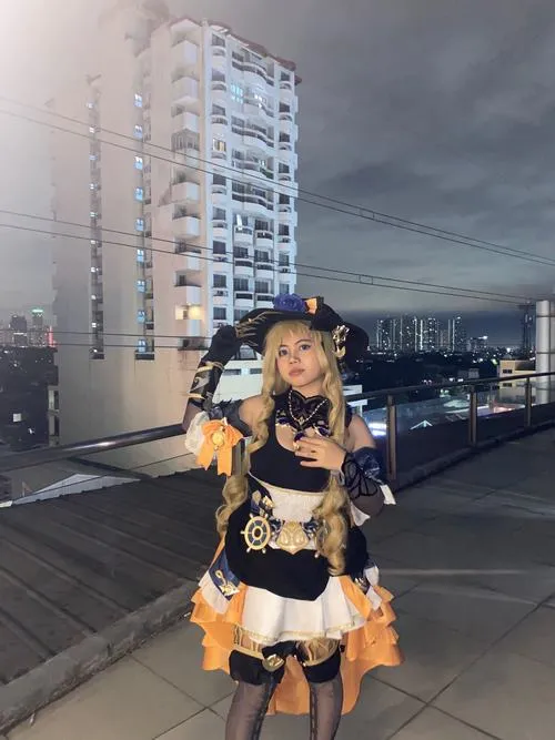 29 Mỹ nữ diện váy đen vàng đứng giữa sân thượng mang vẻ nổi bật và lấp lánh trong nền trời xám