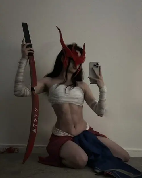 1 Cô nàng cosplay Ahri quỳ nhẹ với tai cáo đỏ thần thái ma mị và đạo cụ chai rượu đậm chất nữ tướng