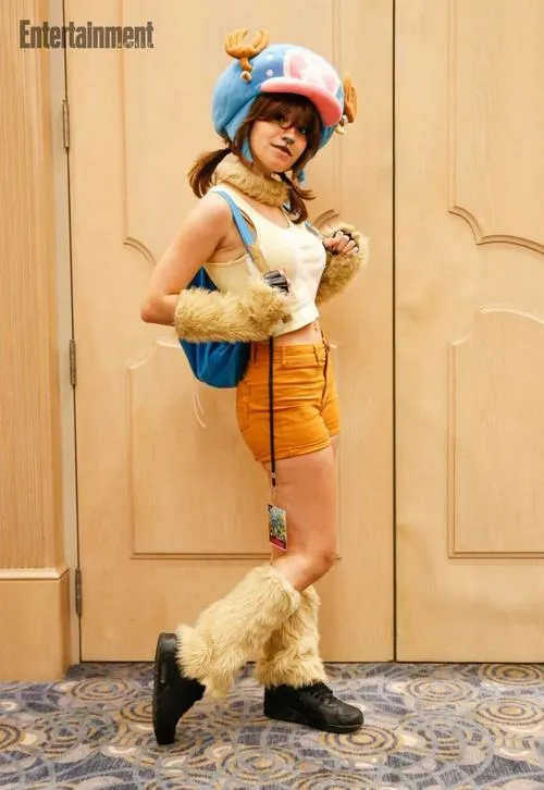 32 Nami đứng trên ghềnh đá sát biển với mái tóc cam và gậy thời tiết tạo cảm giác rất sống động