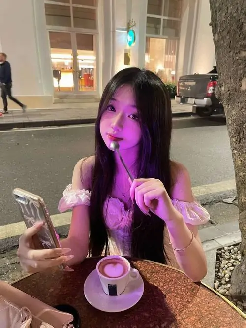 22 Ánh đèn tím nơi tiệm cà phê khiến cô gái cầm ly nhỏ hiện lên nổi bật với kiểu tóc trẻ trung