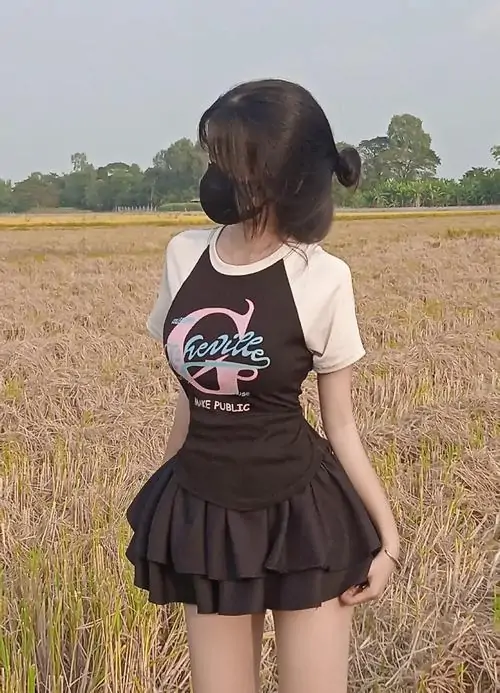 11 Cô gái giữa cánh đồng lúa nghiêng người tránh ống kính để tóc ngắn và váy tối màu nổi bật hơn