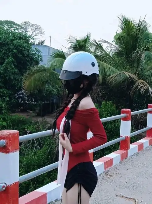 14 Cô gái đội mũ bảo hiểm đứng bên lan can quay lưng nhìn xa làm dáng đứng thoải mái trông gần gũi hơn