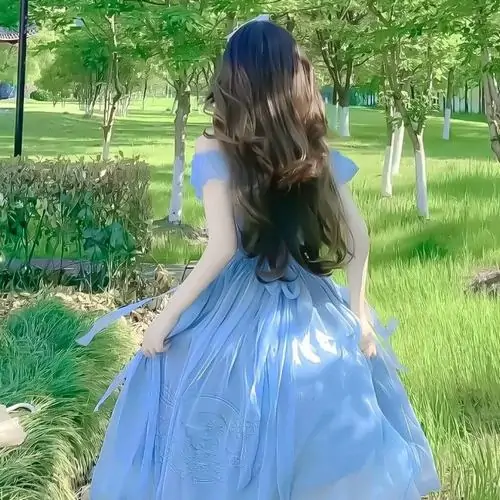 22 Cô gái trong váy xanh bồng bềnh quay lưng giữa công viên làm dáng vẻ mềm mại hòa cùng nền cỏ sáng