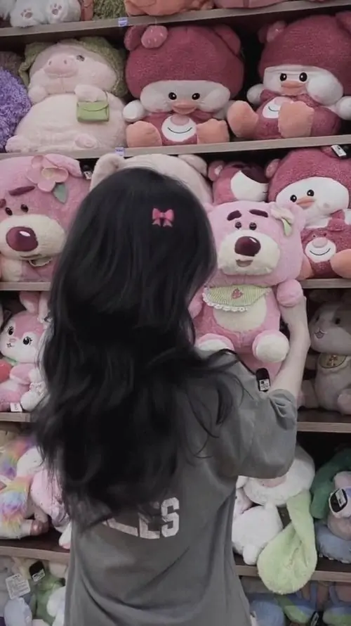 29 Cô gái quay lưng trước kệ gấu bông với tóc xõa dài tạo cảm giác dễ thương hợp không gian hồng