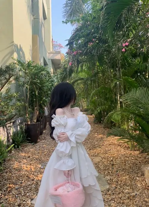 4 Ảnh gái dễ thương che mặt với váy trắng xếp tầng giữa lối cây xanh quay lưng khoe bàn tay nhỏ xinh