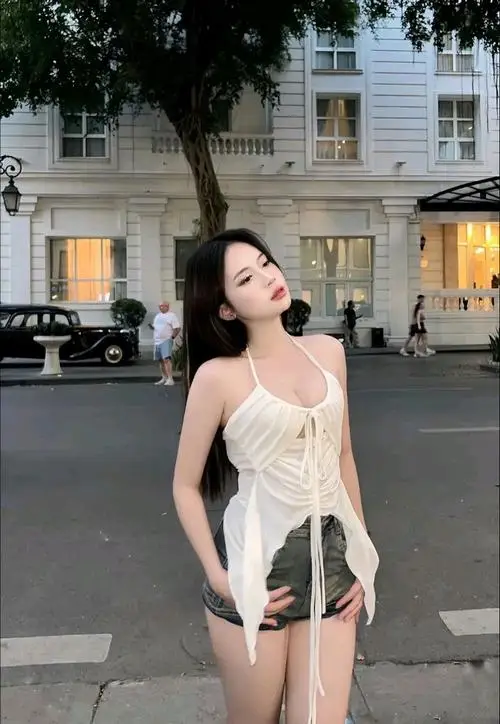 17 Cô nàng đứng giữa phố với áo trắng ôm nhẹ tôn tổng thể cao ráo và đường cong mềm