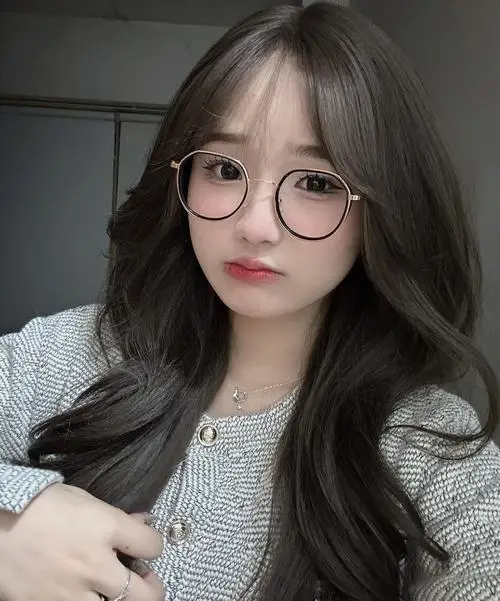 15 Gái xinh ngồi trong phòng với kính tròn và gương mặt hài hòa đem lại cảm giác gần gũi mà không nhạt