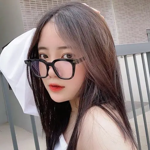 18 Thiếu nữ dễ thương nghiêng đầu bên ghế với gọng kính đen làm nổi đôi mắt và khí chất hiện đại