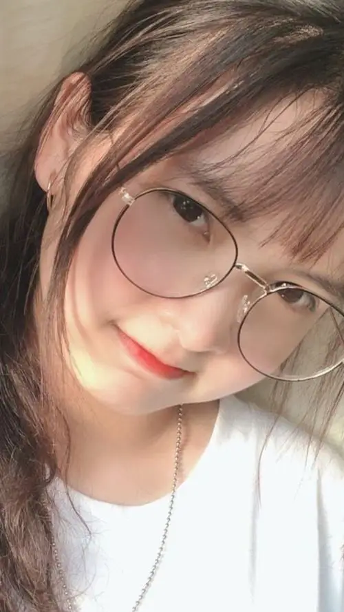 23 Gái xinh nghiêng đầu trong ánh sáng mềm với kính mảnh và nét mặt hài hòa trông vừa xinh xắn vừa tinh tế