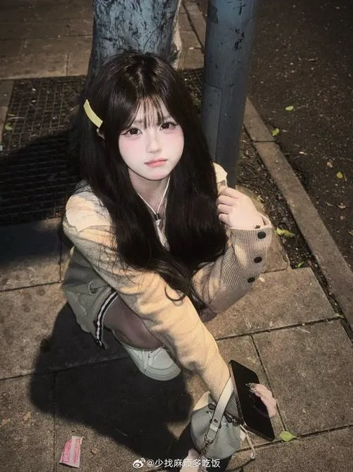 15 Ảnh gái xinh ngồi trên vỉa hè buổi tối với áo khoác sáng màu tóc tối xõa dài và ánh nhìn trầm dịu