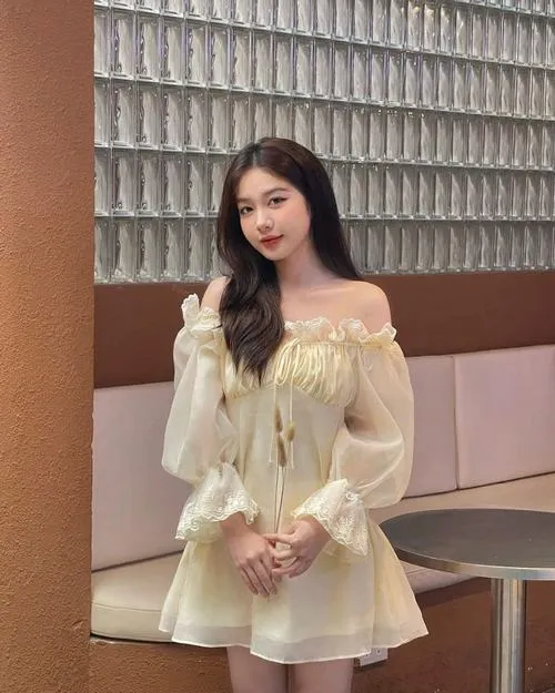 24 Nàng thơ cute mặc váy vàng tay phồng đứng trước tường kính sóng tóc nhẹ và nụ cười đầy trẻ trung