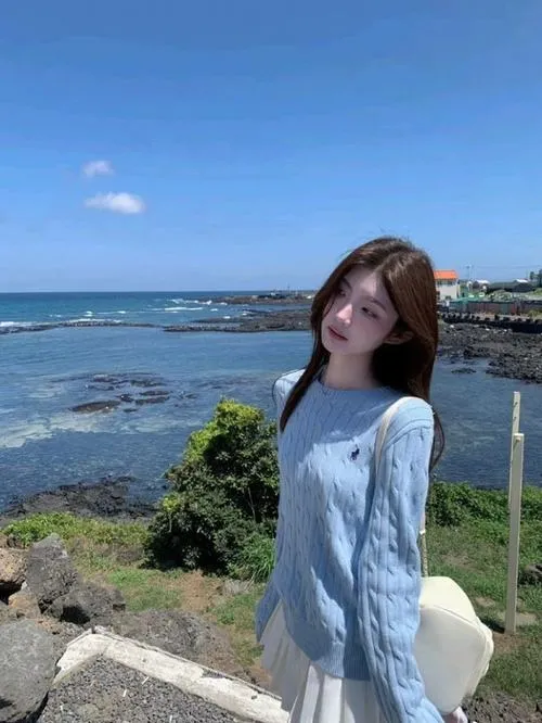 27 Hot girl đứng trước biển rộng với váy xanh dài bay nhẹ theo gió tóc nâu xõa sau lưng rất thơ