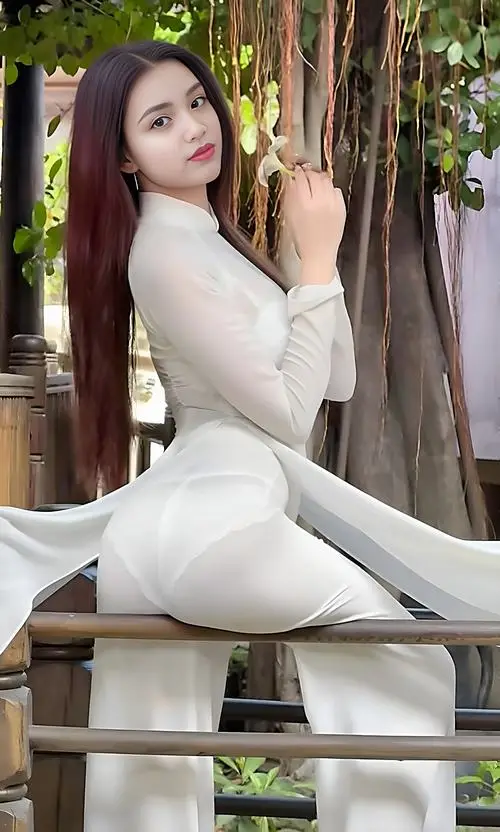 4 Ảnh cô gái mặc áo dài trắng đứng giữa sân trường đầy nắng khoe nụ cười tỏa nắng và vẻ đẹp thanh thoát.